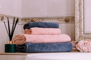 Spa, bathroom background. Stack of clean and folded towels. Bathroom and resort concept and interior accessories with copy space. Neutral beige colors.