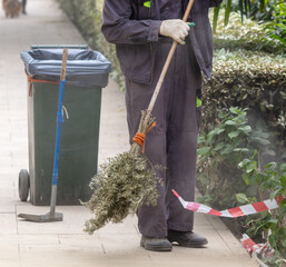 A janitor sweeps the street in the park