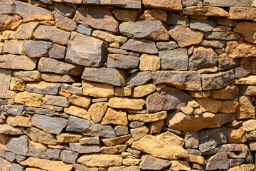 Fototapeta premium Fond de texture de mur en pierre - revêtement en pierre grise avec des pierres de différentes tailles. Modèle de mur en pierre à rayures