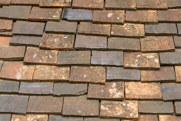 Vue de dessus de vieilles tuiles en terre cuite sur le toit de certaines maisons. La terre cuite est l'un des plus vieux matériau naturel de construction.