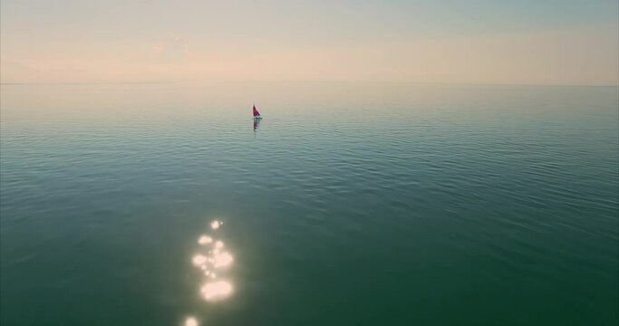 Small sailboat in tranquil calm water at sunset, giving the feeling of bliss. First Encounter Beach, Cape Cod, Massachusetts, United States of America.
