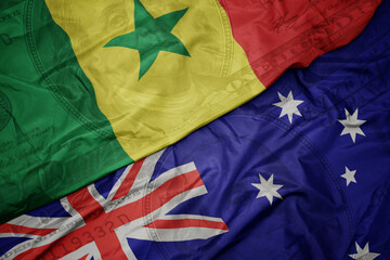 waving colorful flag of senegal and national flag of australia on the dollar money background. finance concept.