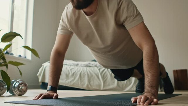 Strength training. Close up of bearded guy doing push ups exercise at home
