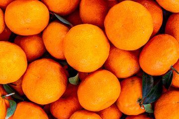 orange mandarin background of fresh juicy tangerines close up, vegan friut conception of citrus