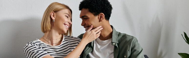 A young multicultural couple enjoys a moment of intimacy and affection in their modern apartment.
