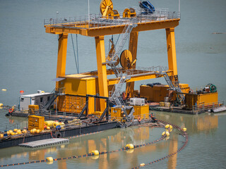 Industrial dredging machine on water used for extracting materials from riverbed or seabed. Yellow...