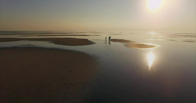 People playing in to water at low tide on tranquil heavenly beach at sunset First Encounter Beach, Cape Cod, Massachusetts, United States of America.