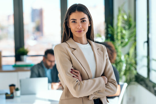 Beautiful young business woman standing while smiling looking at camera in the office