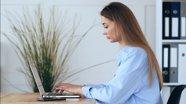 Work from home. Young woman typing plan on laptop computer, side view