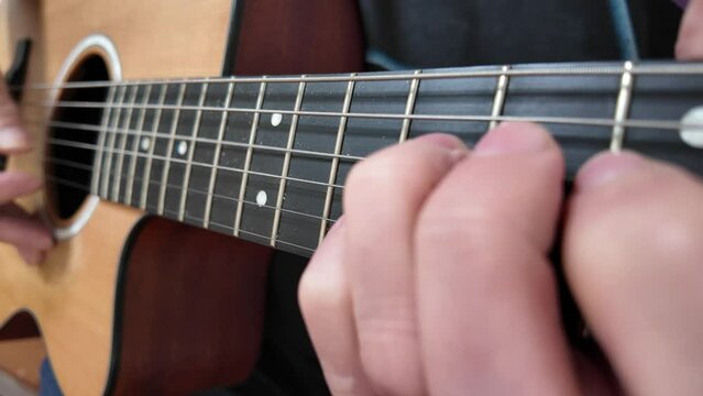 person playing accoustic guitar