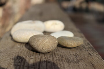 Beautiful round stones lie on a wooden floor, close-up, blurred background.