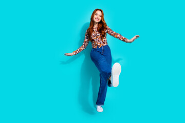 Full size photo of attractive young woman dancing have fun dressed stylish colorful clothes isolated on cyan color background