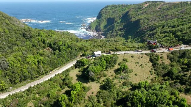Aerial View Of Tractor Pulling House Across Road In Chiloe, Chile. This Is called Minga, A South America term meaning - coming together for the common good. Orbit Motion