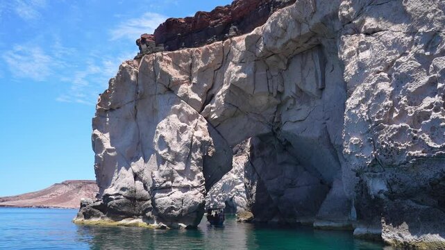 Boat tour exploring Isla Espiritu Santo passing thru a rock arch, BCS