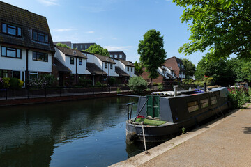 London - 06 04 2022: View of Regent's Canal with houseboat and Victorian style terraced houses