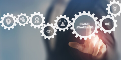 Brand awareness concept. A businessman interacts with virtual gears symbolizing various aspects of brand awareness. Marketing strategies for building and maintaining brand recognition and reputation.