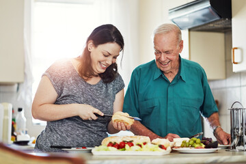 Elderly father, daughter and cooking in kitchen for lunch with bread slice, fruit and wellness food for retirement. Senior dad, woman and prepare cheese platter in home for diet, nutrition and health