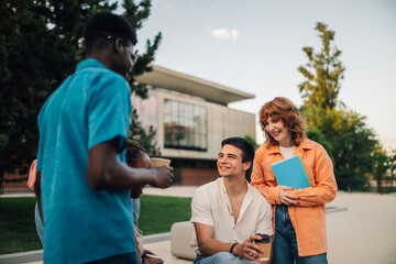 Happy interracial college students having coffee break at campus.