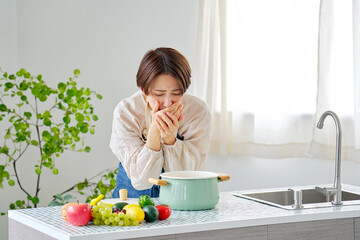 キッチンで吐き気がする女性
