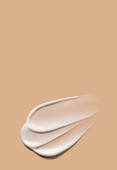 creamy smear of white cosmetic texture on beige background skin care concept