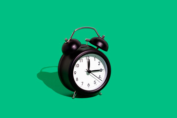 Retro alarm clock against green background