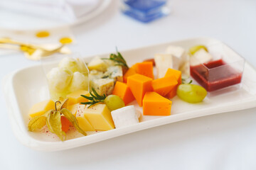 Plate with assorted cheeses and sauce. Appetizer for the buffet. Banquet menu for the holiday.