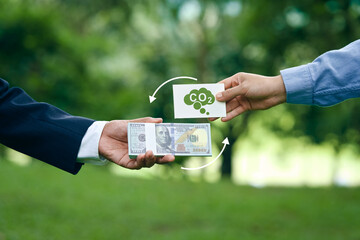 Businessman holding a US dollar banknote And another person held up a sign with the CO2 icon. The...