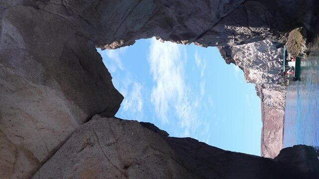 Boat tour exploring Isla Espiritu Santo passing thru a rock arch, Baja California Sur