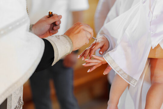 The priest conducts the process of anointing with oil for baptism. Christian faith and traditions.