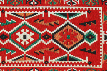 Traditional Turkish carpet and kilim motifs. There are geometric motifs on a red background.