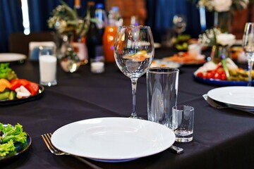 Empty glasses and a plate on a served banquet table. Catering.