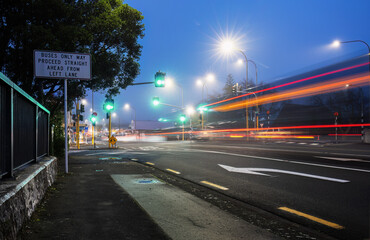 Long exposure image of bus light trails driving through green traffic lights in heavy fog. Auckland.