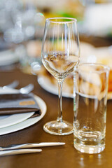 An empty wine glass and a glass on the served dining table. tableware for a banquet. catering services for the holiday.