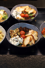 plato preparado de ensalada  con queso fresco, tomate,  pavo, nueces y pasas