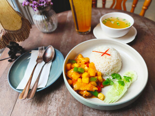 Rice and fried chicken with vegetable tomato sauce on plate.