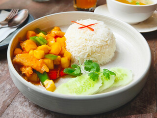 Rice and fried chicken with vegetable tomato sauce on plate.