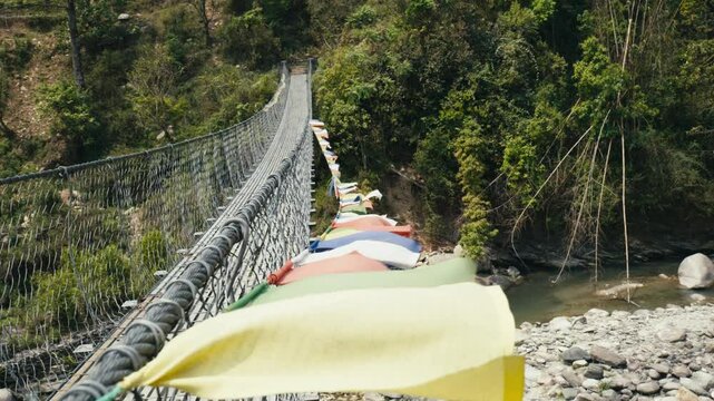 Suspended bridge and buddhist prayer flags in Nepal