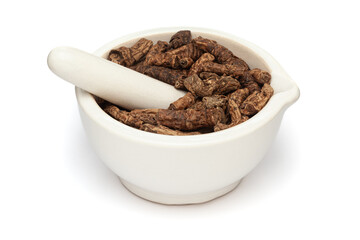 Close-up of Dry Organic Hellebore or Kutki (Picrorhiza kurroa) roots, in white ceramic mortar and...