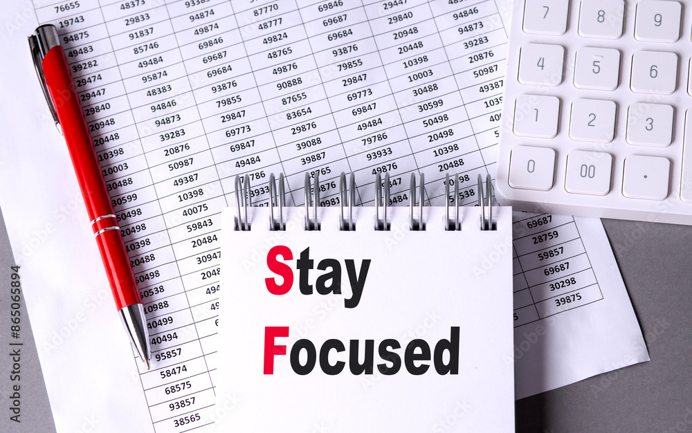 Poster stay focused text on notebook with chart , pen and calculator
