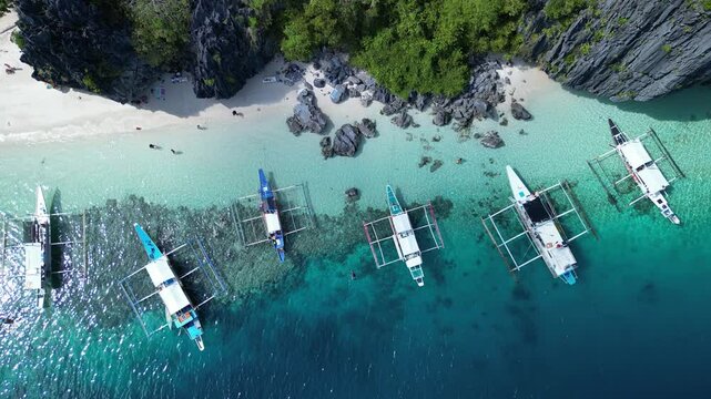 Aerial footage of the boats moored along Talisay Beach in Tapiutan Island, El Nido, Philippines