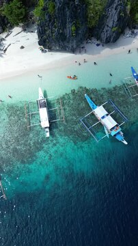 Drone footage of boats moored along Talisay Beach in Tapiutan Island, El Nido, Palawan, Philippines