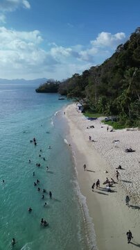 Drone footage of tourists at Seven Commandos Beach on a sunny day in El Nido, Palawan, Philippine