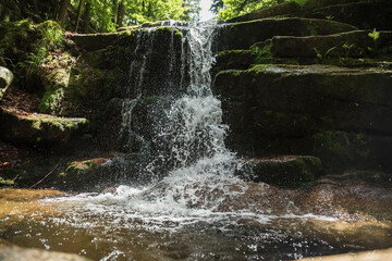 wodospad w leśnym otoczeniu, bujnej zieleni lata.