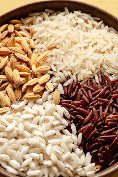 Detail of different types of rice: 'Risone' (raw rice') Basmati, Carnaroli, Long wholemeal red rice. Front view.