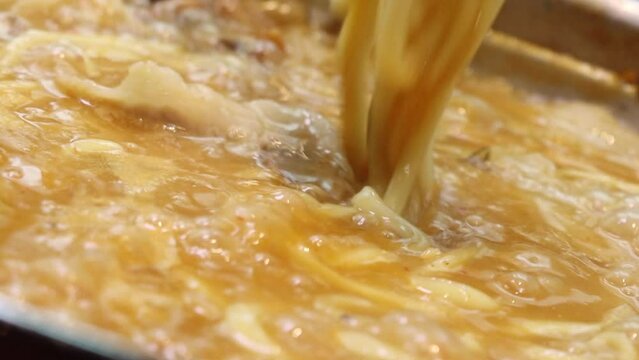 팔팔 끓는 전골 국물 속에 든 칼국수 사리