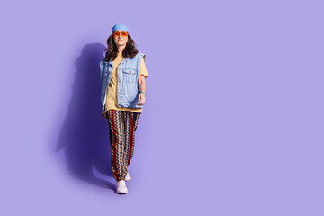 Full length photo of lovely pensioner lady walking model dressed stylish denim hipster garment isolated on purple color background