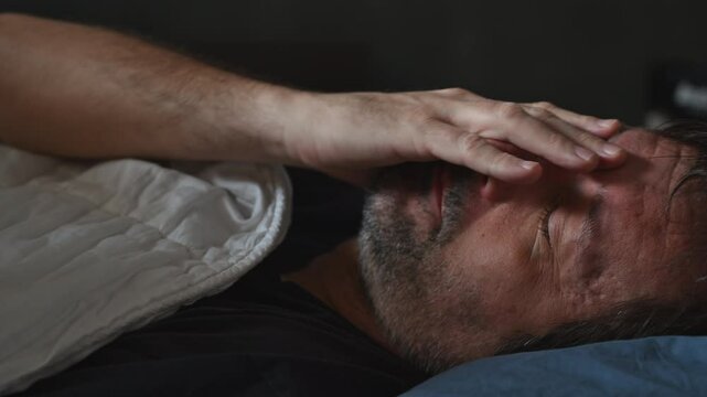 Tired mature man trying to fall asleep