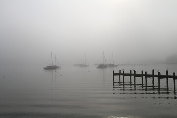 Obraz premium some sailing boats in the backlight on Lake Ammersee in the morning mist