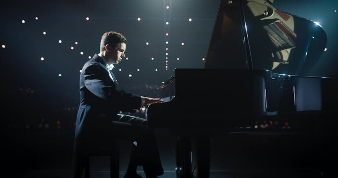 Zoom Out From Pianist's Hands. Male Performing Classical Instrumental Music on Stage. Musician Using a Grand Piano to Create Beautiful, Melodic Improvisation. Spectators Sitting in the Concert Hall