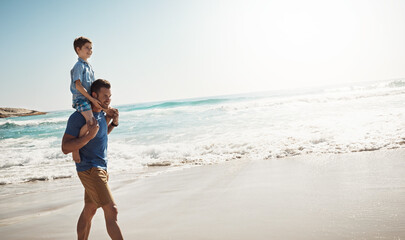Dad, ocean and boy child on shoulders for walk, vacation and sunshine to relax with care, love or bonding. Man, father and son with piggy back, connection and outdoor by waves, sea and mockup space © ReeseArcurs/peopleimages.com